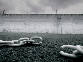 a chain is laying on the ground in front of a wall
