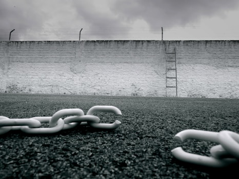 a chain is laying on the ground in front of a wall