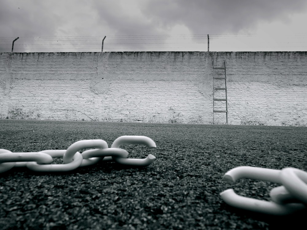 a chain is laying on the ground in front of a wall