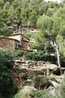 a stone house surrounded by trees and bushes