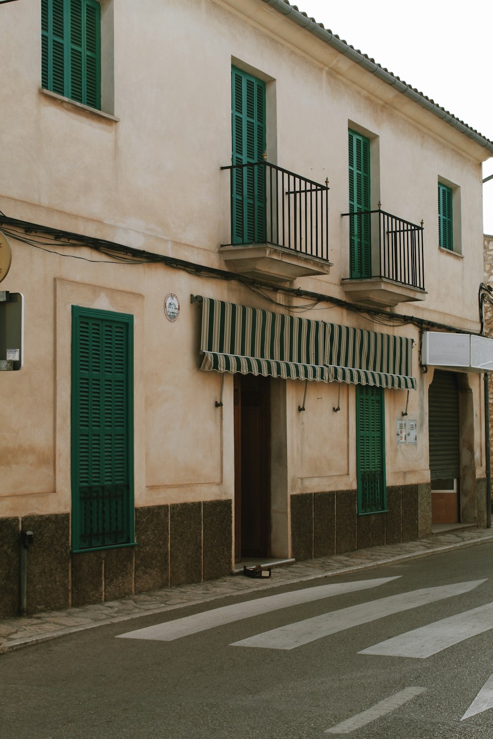 a building with green shutters and a street sign