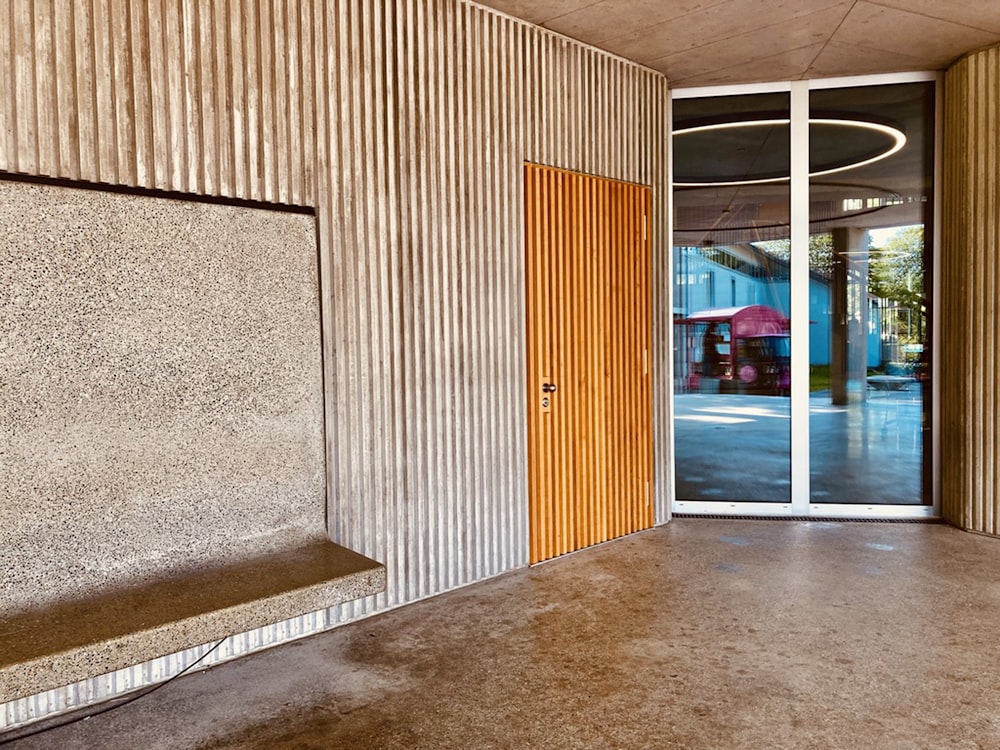 a room with a concrete wall and a wooden door