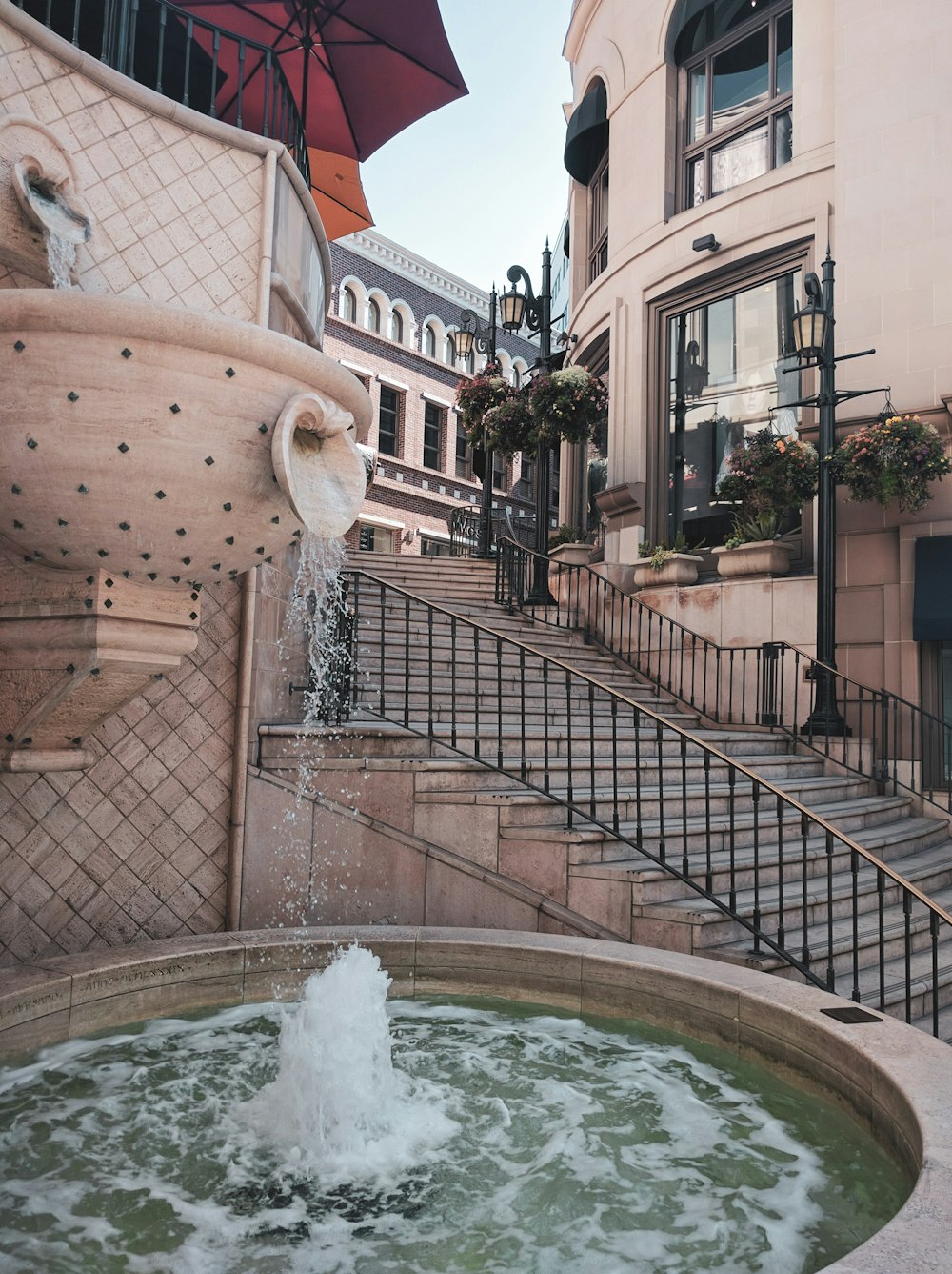 a fountain with a red umbrella on top of it