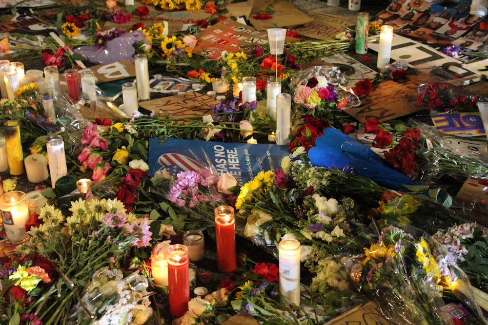 a bunch of flowers and candles on a table