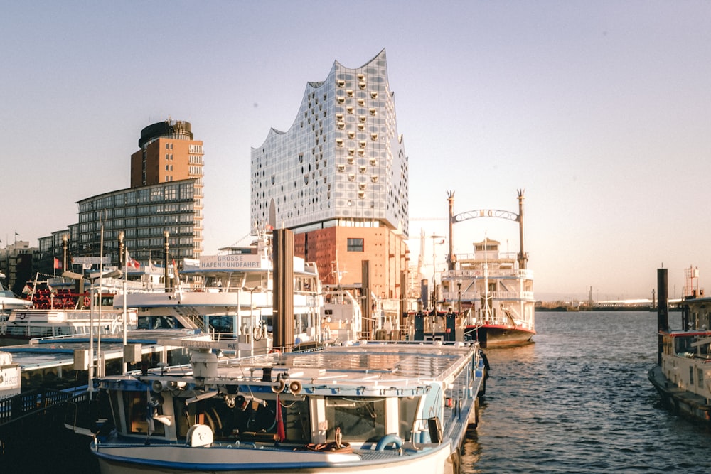 a boat docked in a harbor next to a tall building