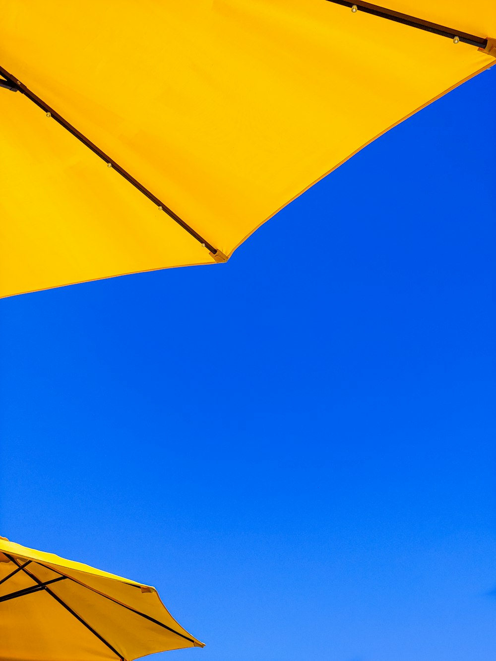 a yellow umbrella with a blue sky in the background