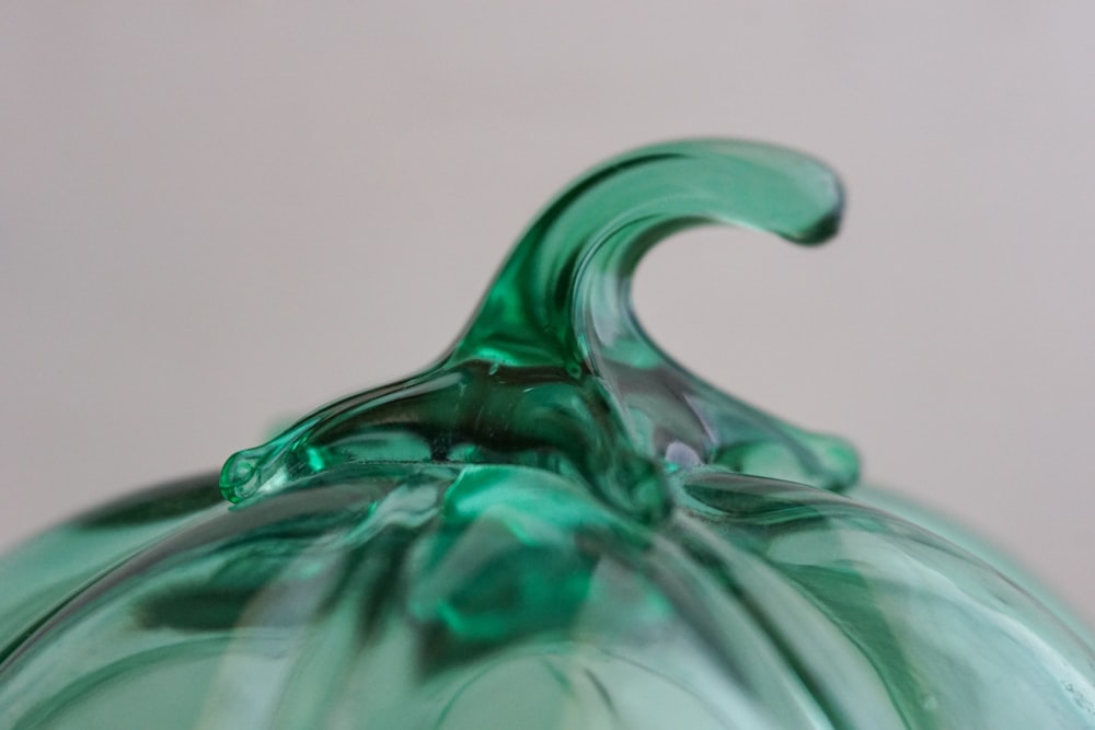 a green glass pumpkin sitting on top of a table