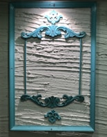 An elegant photo frame with personalized details resting against a dark textured wall.