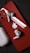 A red smartphone with an Apple logo on the back lies on a dark surface. Two wireless earbuds rest on the phone, and a charging case is nearby.