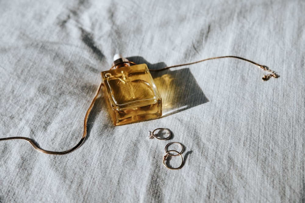 a bottle of perfume sitting on top of a bed