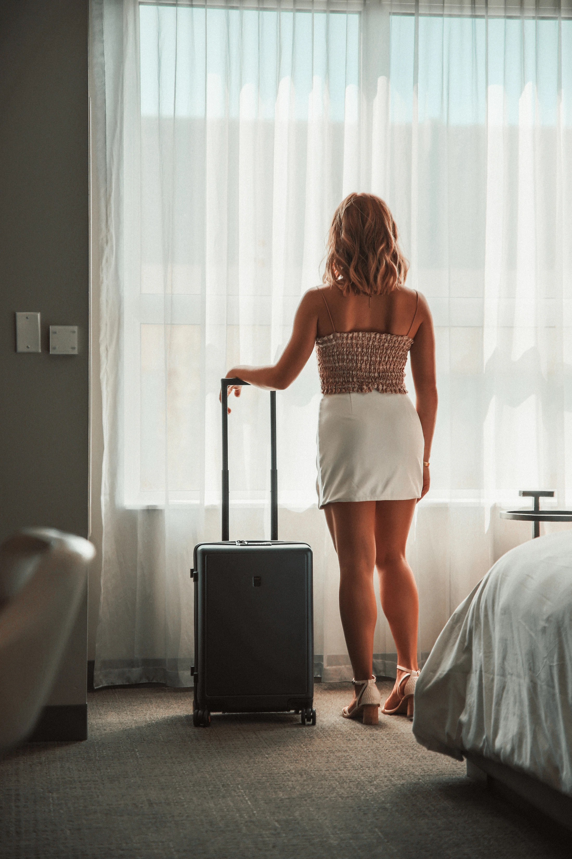Rolling luggage in a bright hotel room ready for an organized journey
