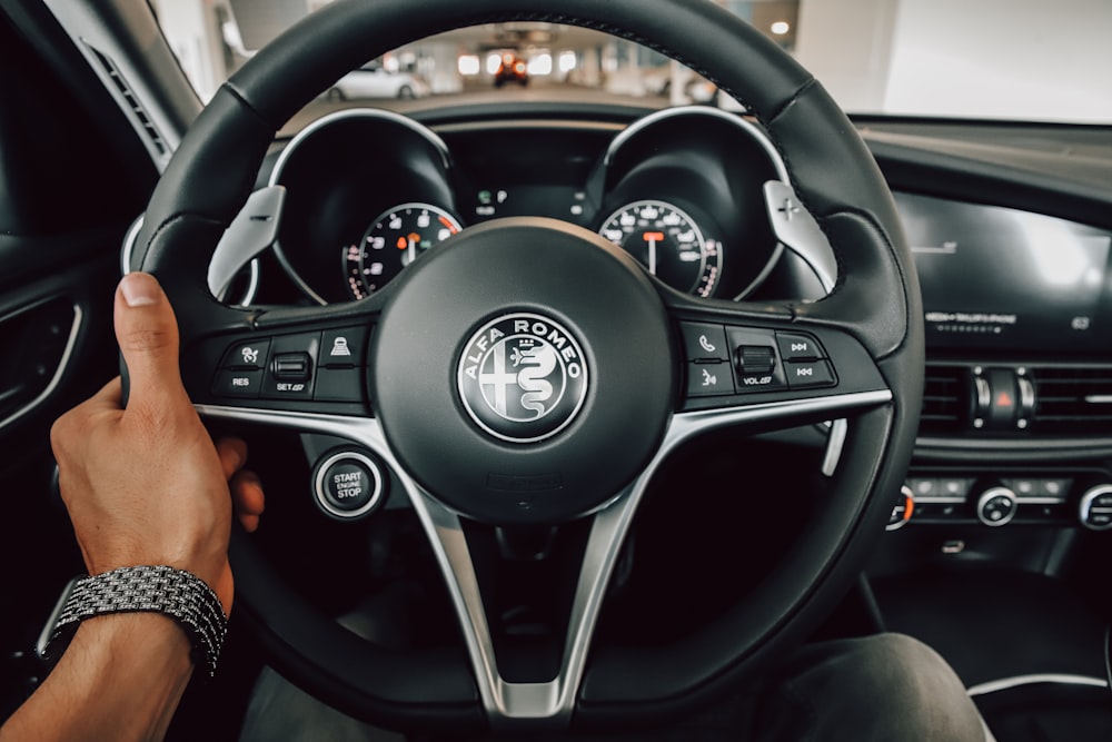 a person driving a car with a steering wheel