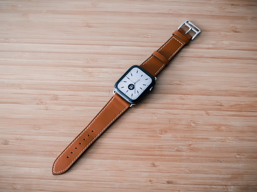 a watch sitting on top of a wooden table