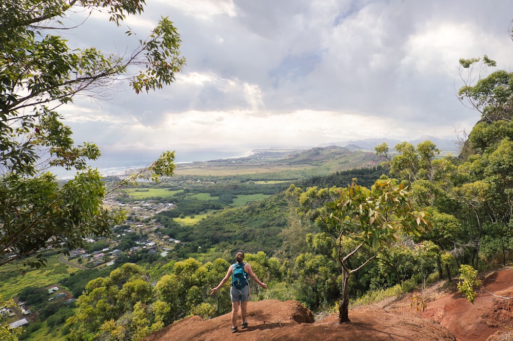 a man hiking up a hill with a view of a valley