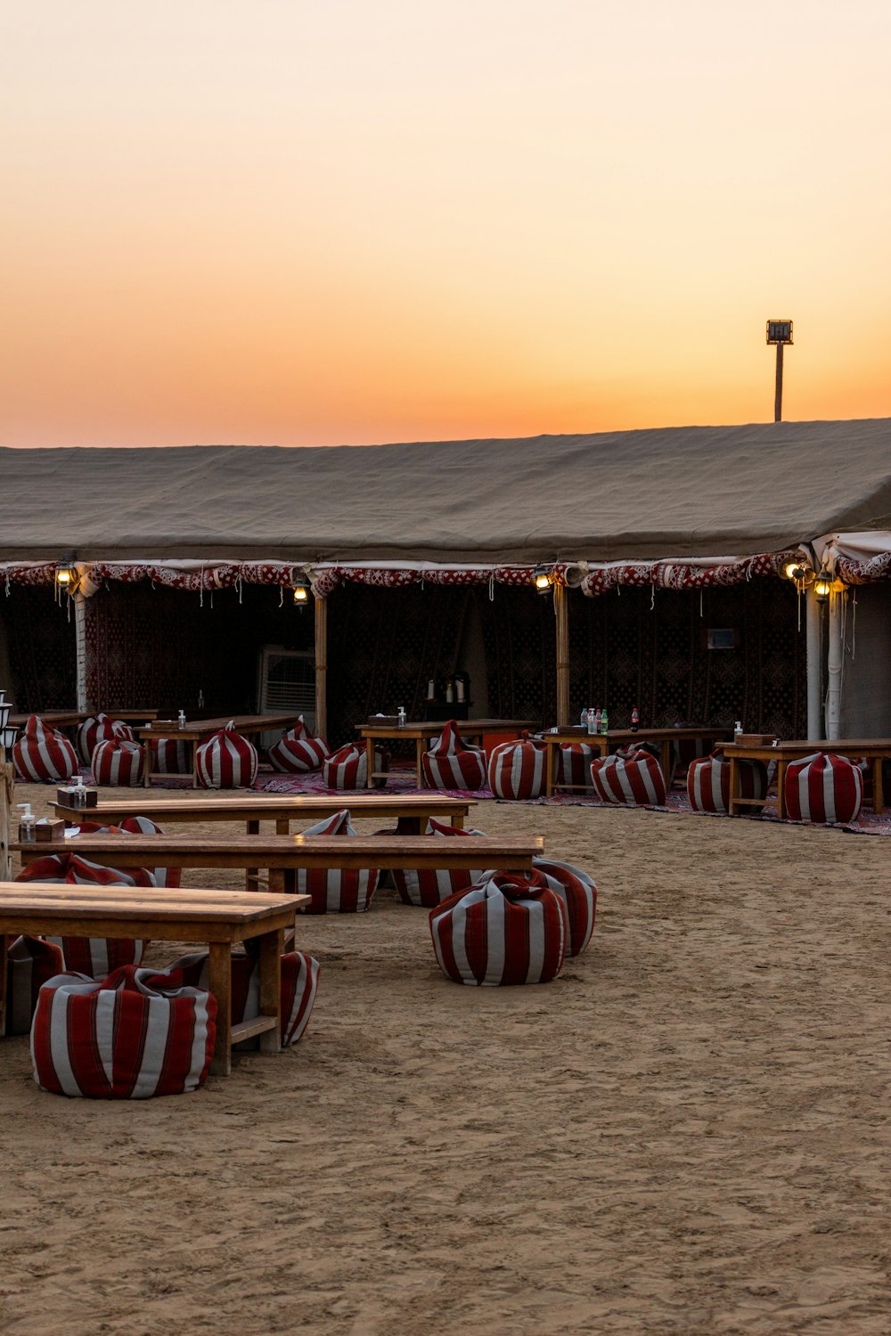 a sandy area with benches and tables in the sand