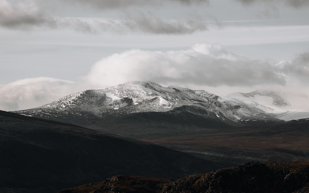 a snow covered mountain in the distance under a cloudy sky