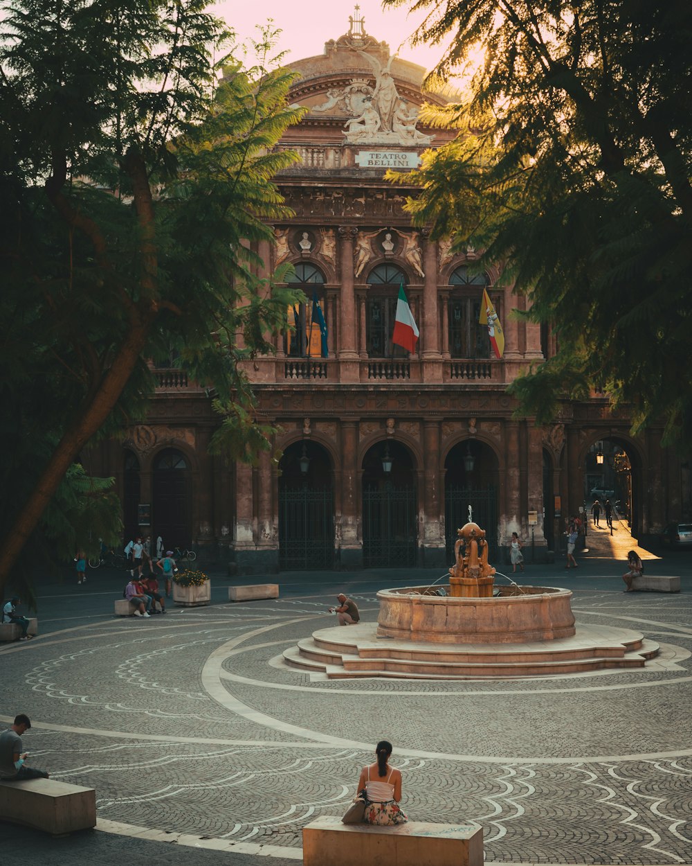 a person sitting on a bench in front of a building