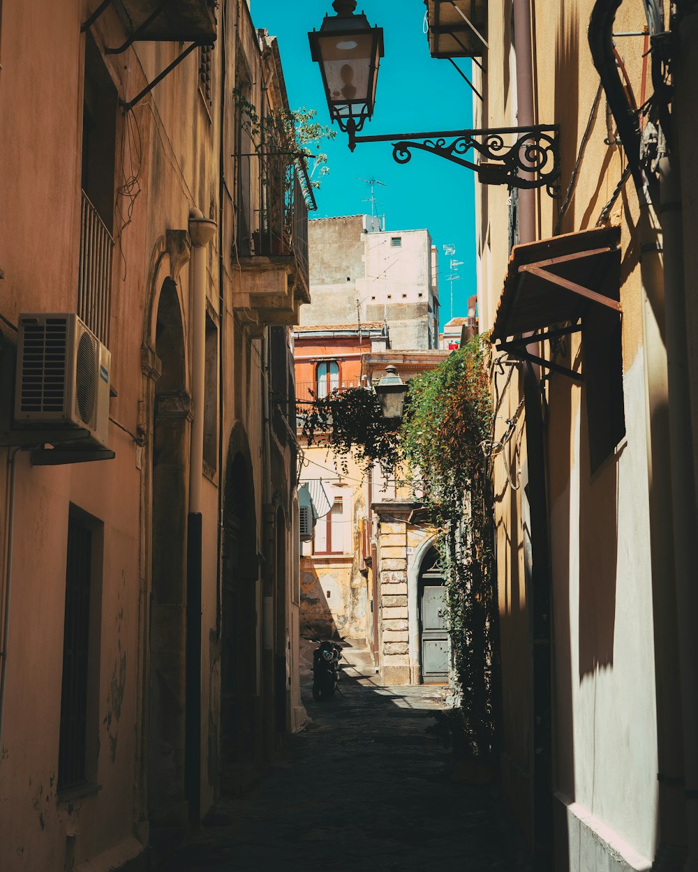 a narrow alley way with a street light hanging over it