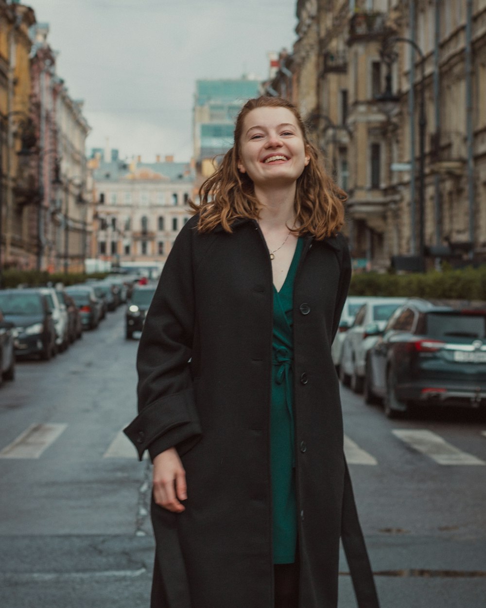 a woman standing on the side of a street