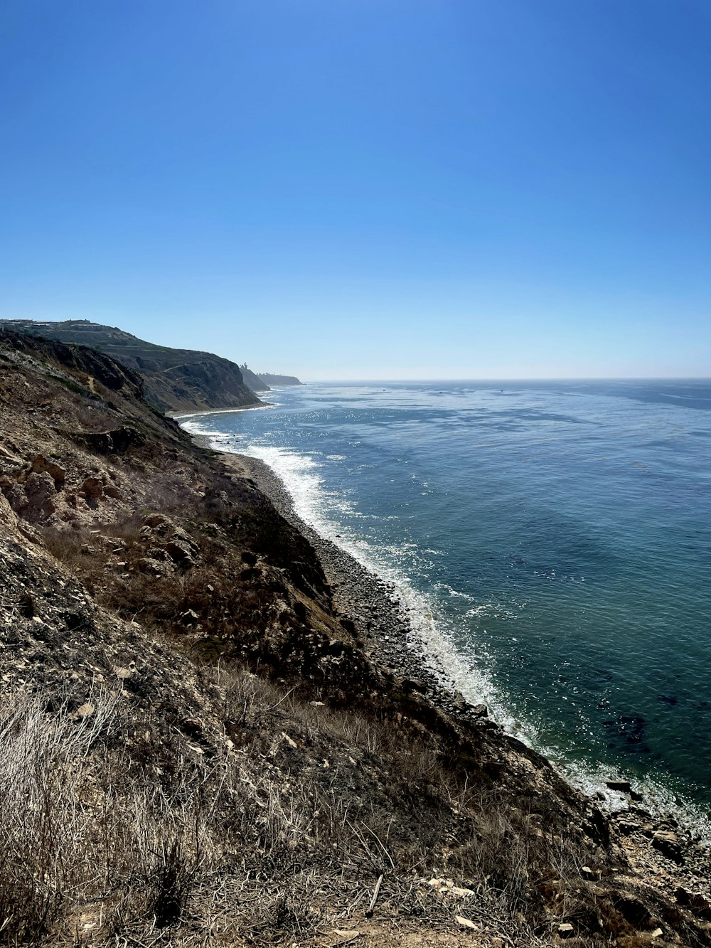 a view of the ocean from the top of a hill