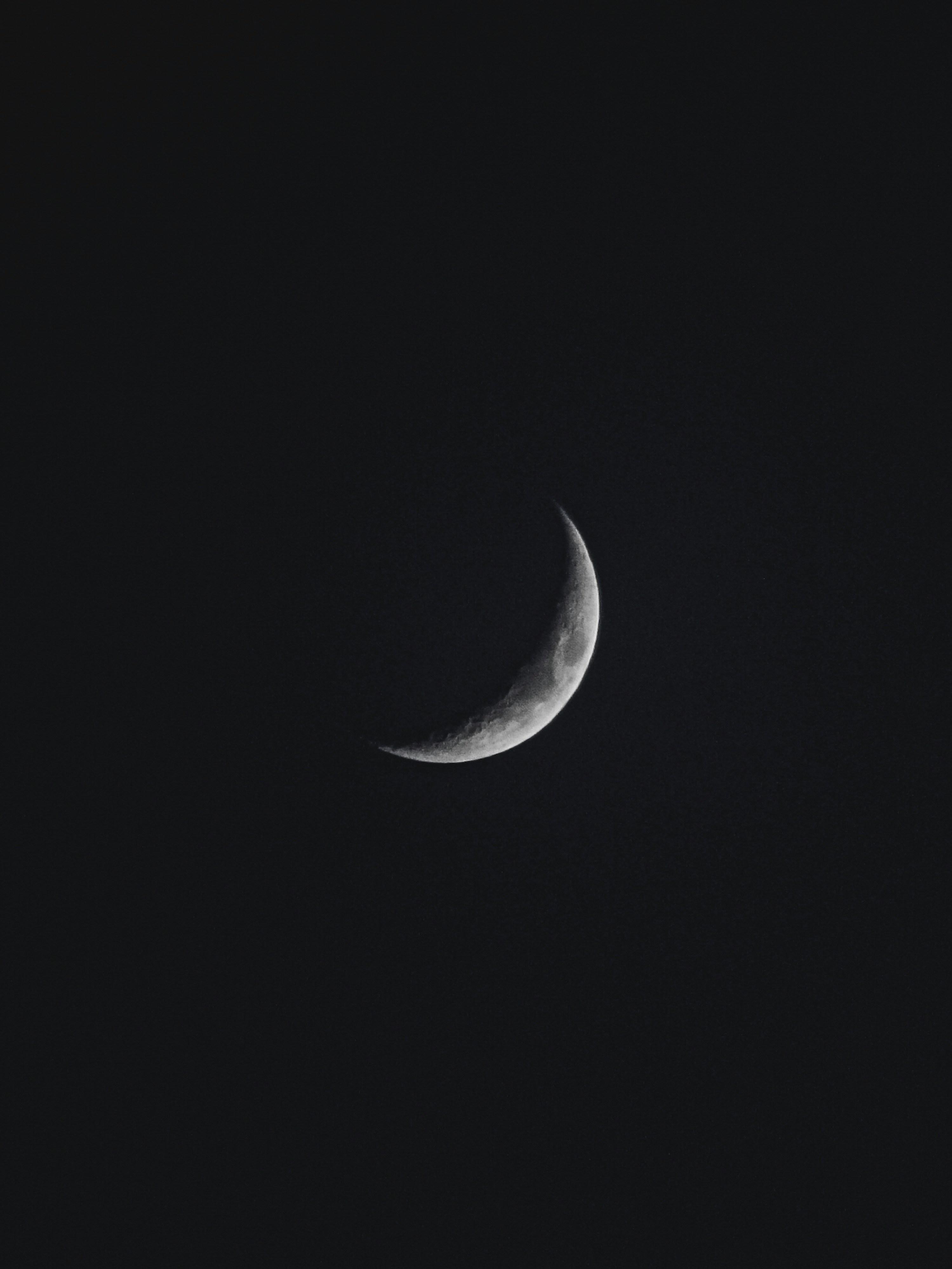 a half moon is seen in the dark sky