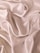 Smooth, flowing folds of shiny, champagne-colored satin fabric create an elegant, luxurious texture.