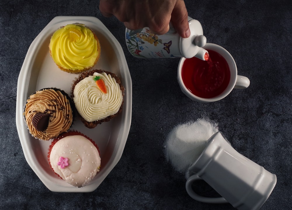 a plate of cupcakes and a cup of tea