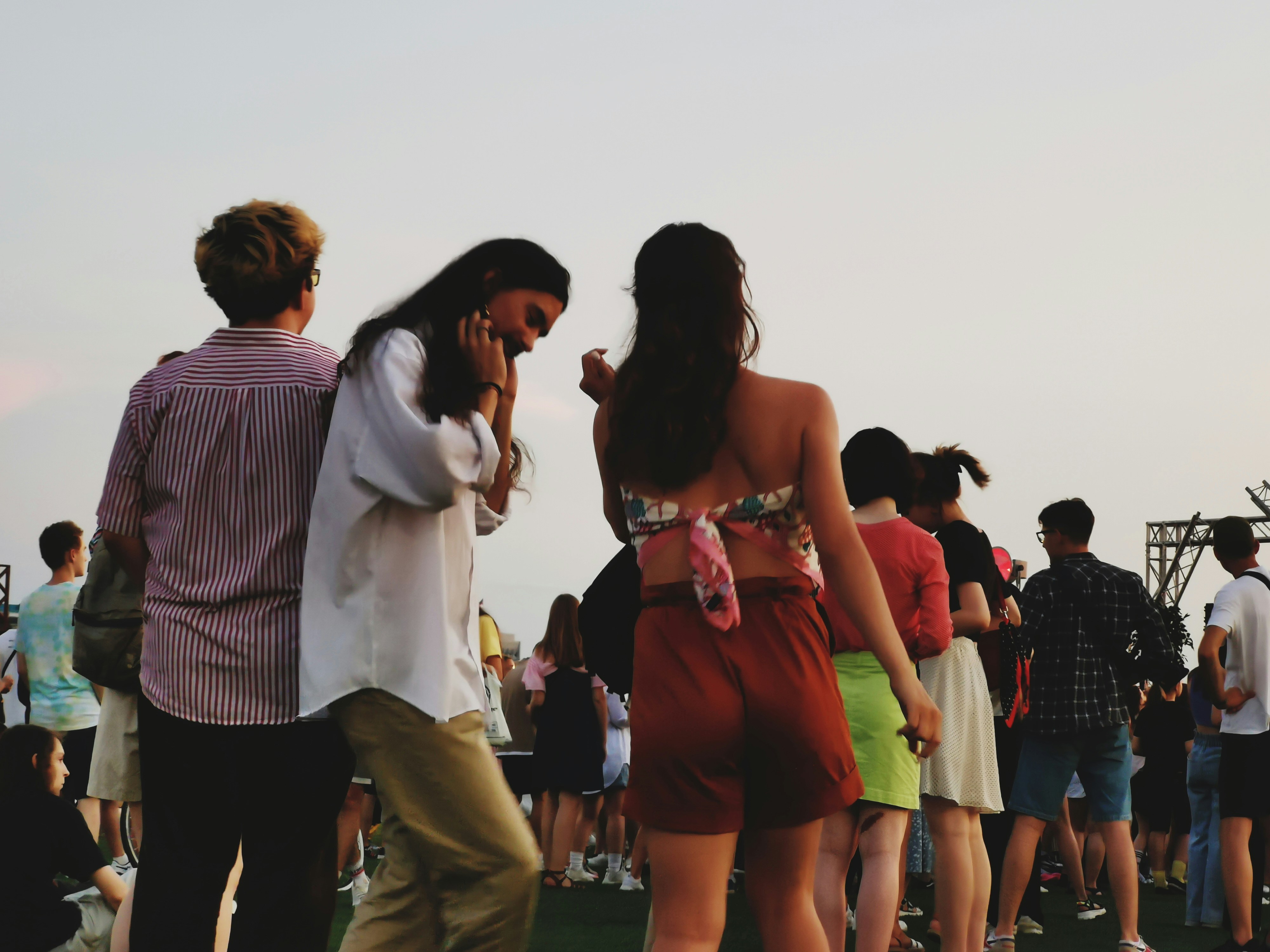 a group of people standing on top of a grass covered field