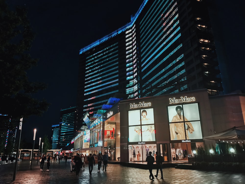 a group of people walking down a street next to tall buildings