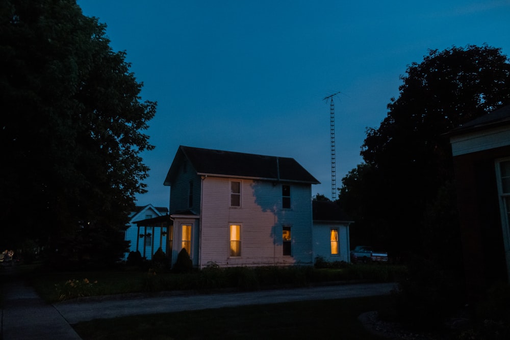 a house is lit up at night with the lights on