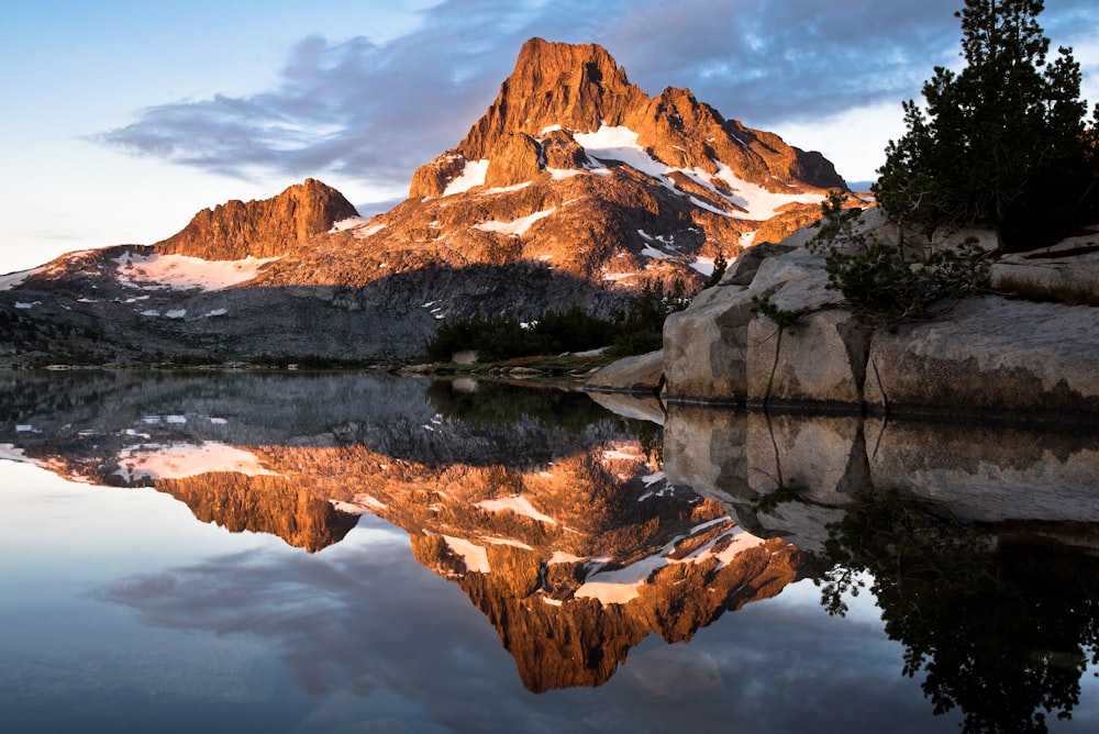 a mountain is reflected in the still water of a lake