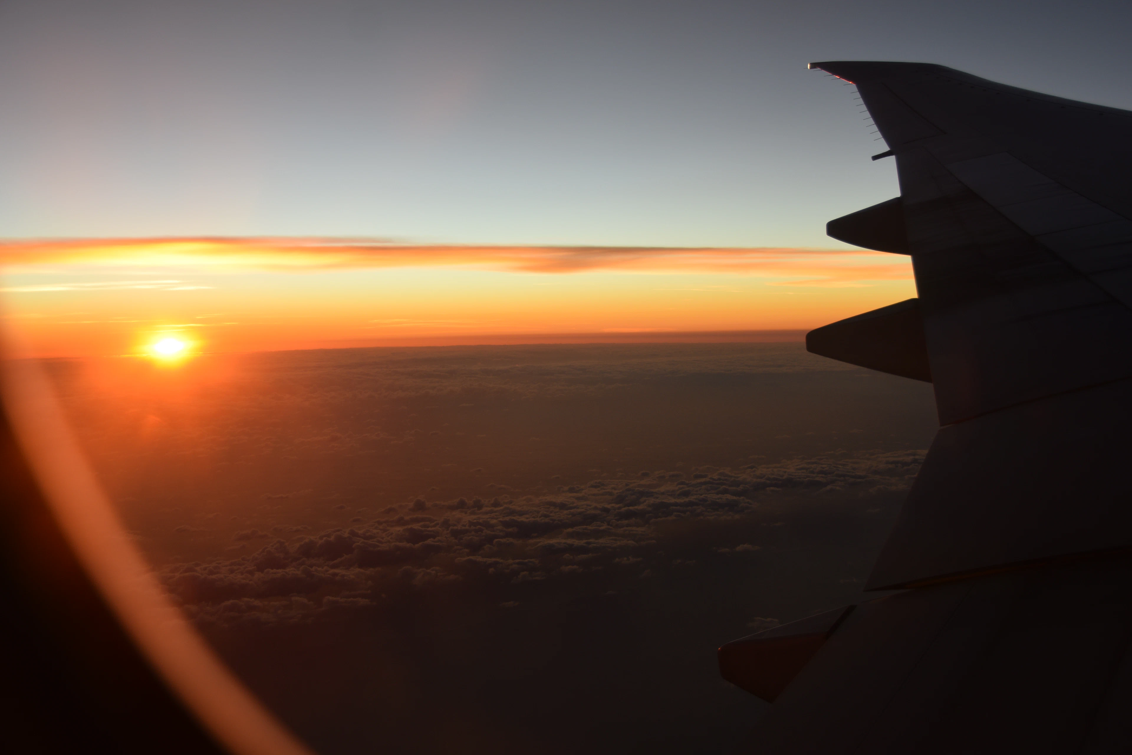 The sun setting over the clouds, seen from an airplane