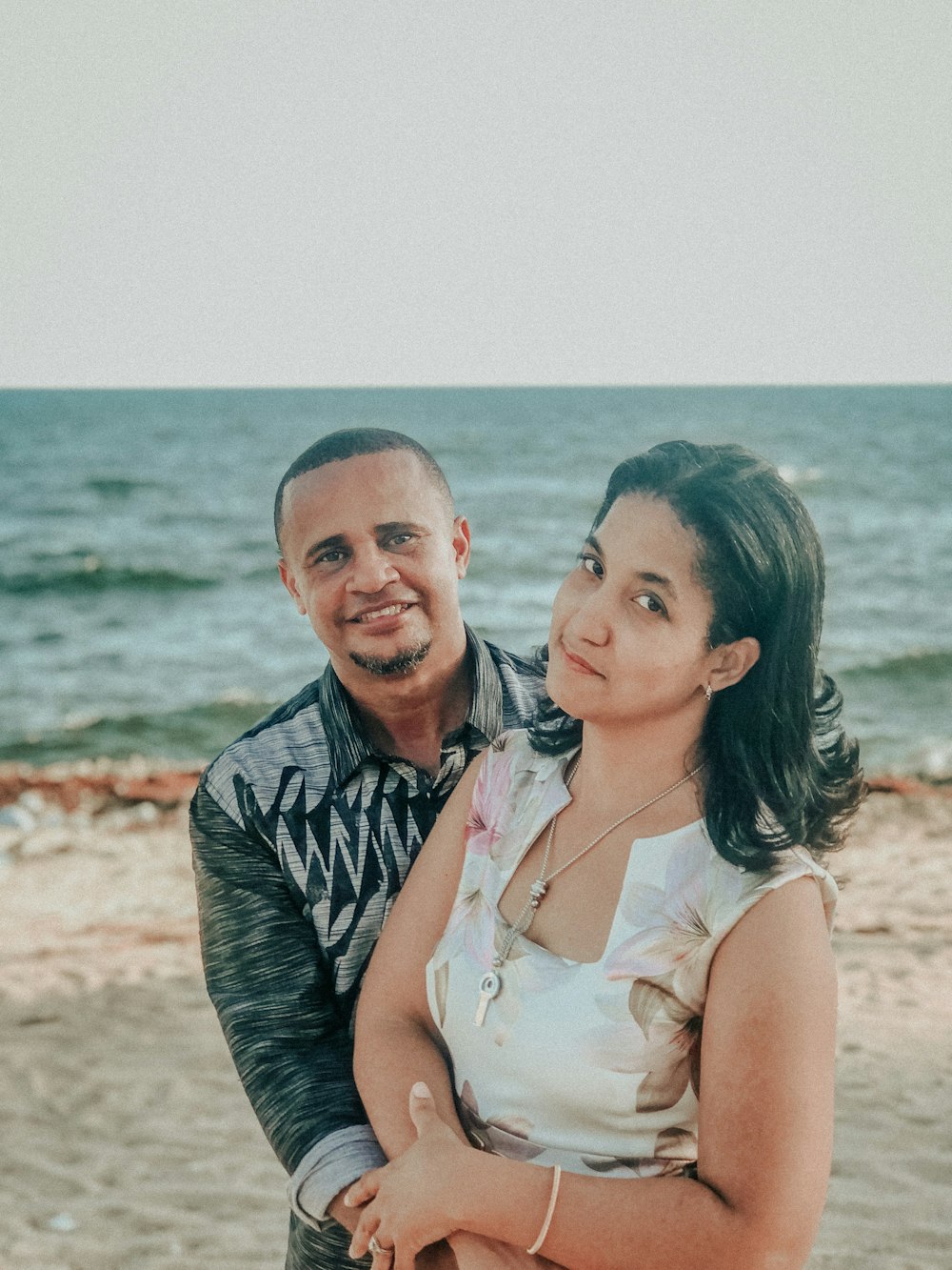 a man holding a woman on the beach