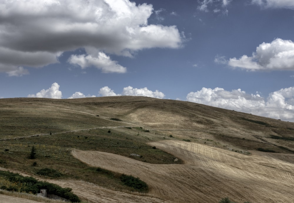 a view of a hill with clouds in the sky