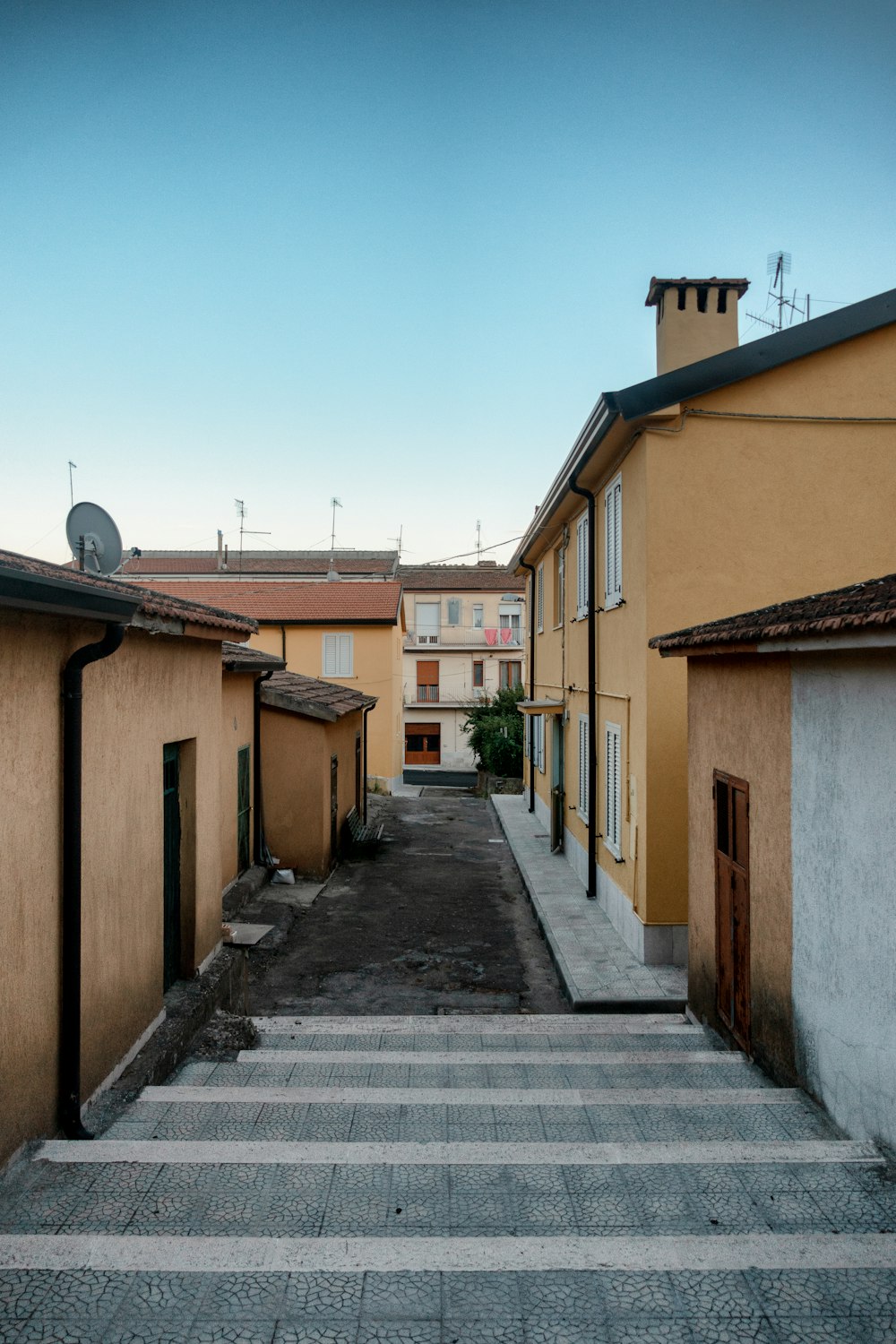 a narrow street with buildings and a clock tower in the distance