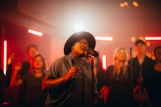 a woman singing into a microphone in front of a group of people