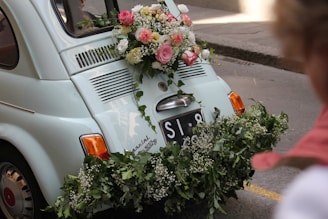 a small car with flowers on the back of it