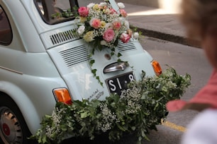 a small car with flowers on the back of it