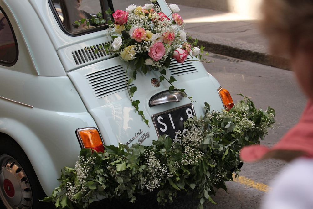 Un pequeño coche con flores en la parte trasera