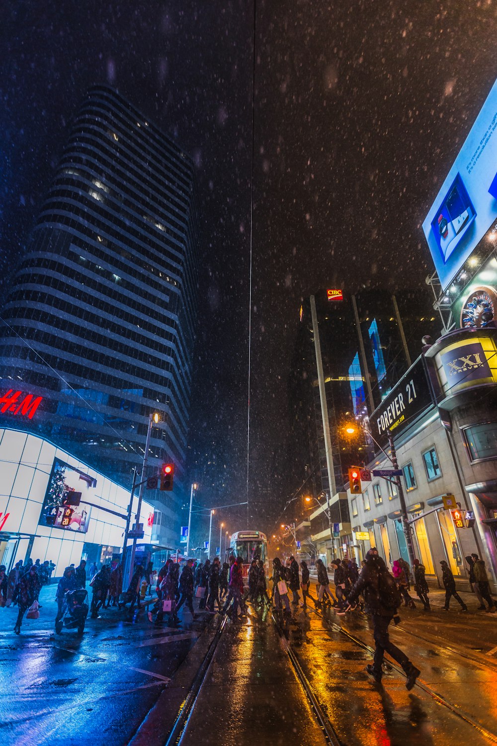 a group of people walking down a street at night