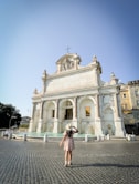 a woman standing in front of a white building