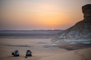 Sunset view over the rocky Agafay desert with a group riding quad bikes