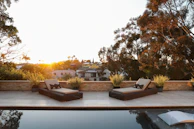 A sunlit outdoor loveseat with plush cushions, perfect for lazy afternoons.
