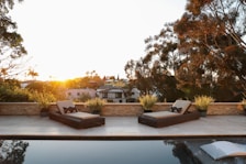 Sunset casting warm light over a villa’s private patio with comfortable lounge chairs.
