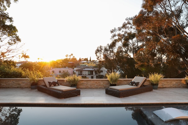 Relaxing hotel terrace with loungers and potted plants catching golden afternoon light.
