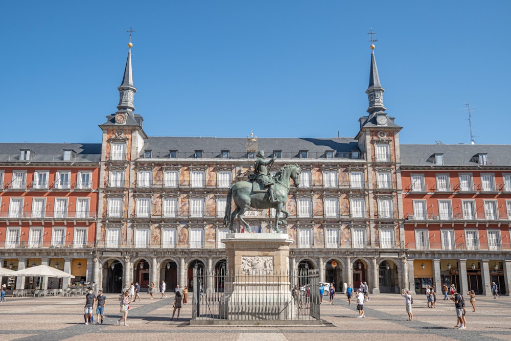 a statue of a man on a horse in front of a building