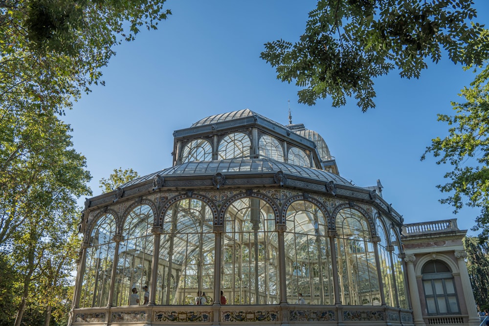 a large glass building sitting in the middle of a park