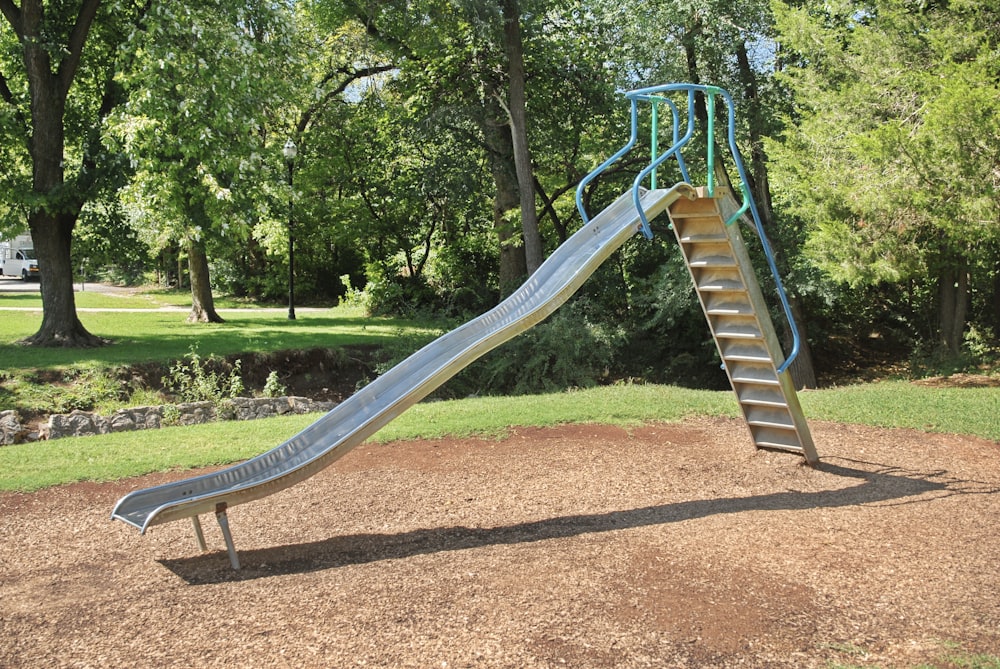 a slide in a park with trees in the background