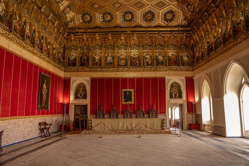 a large room with a red wall and a painting on the wall