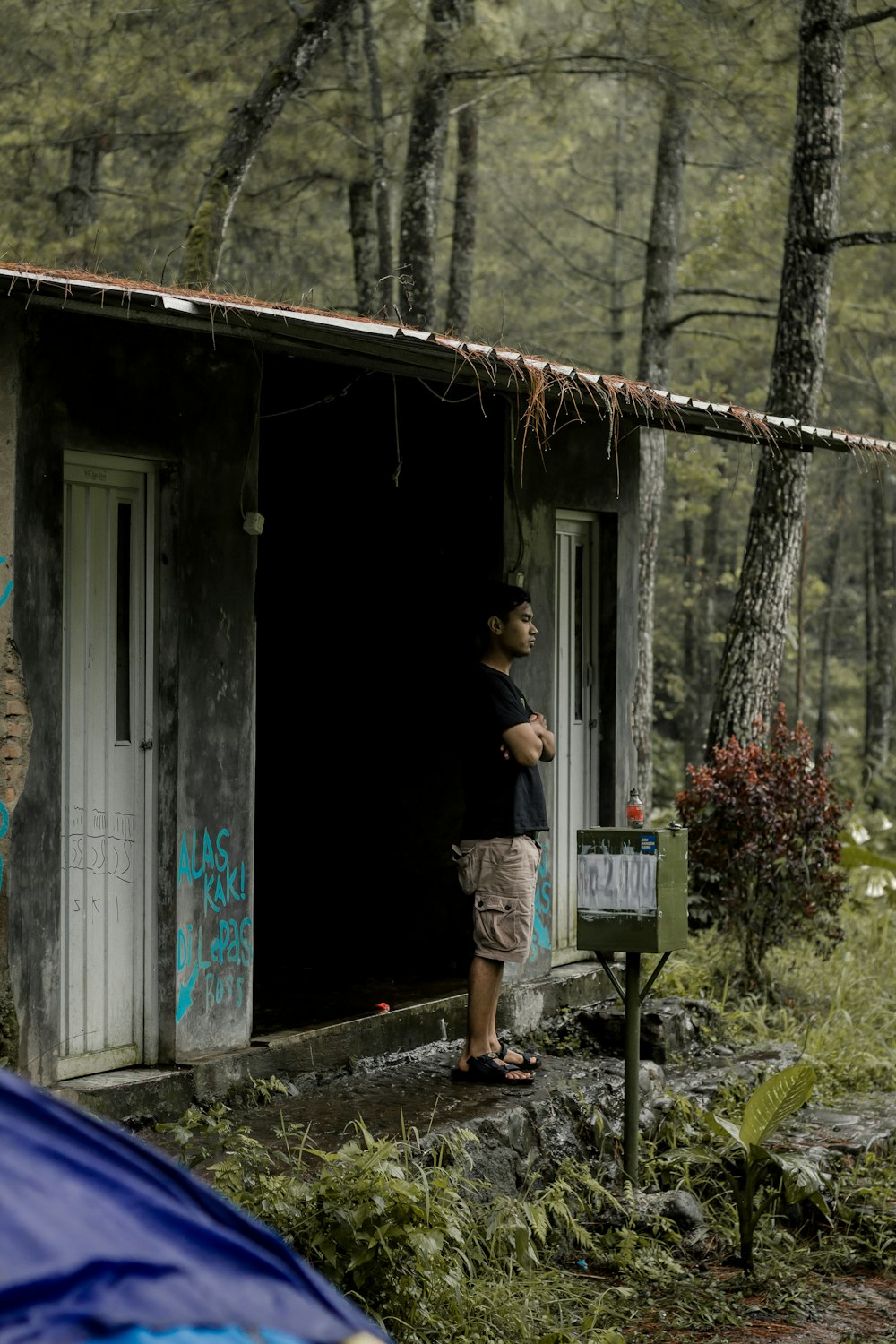 a man standing outside of a small building